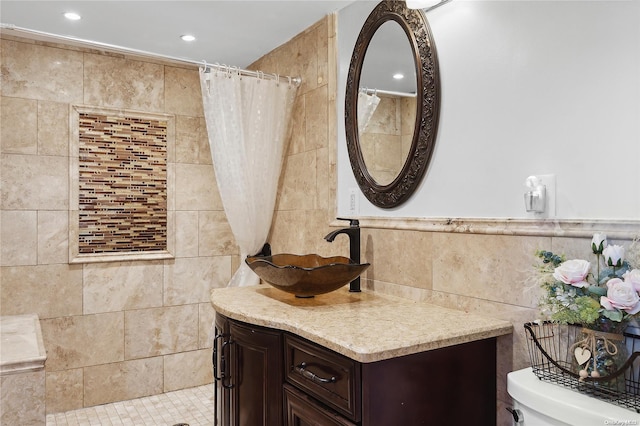 bathroom with a shower with curtain, vanity, tile walls, and toilet