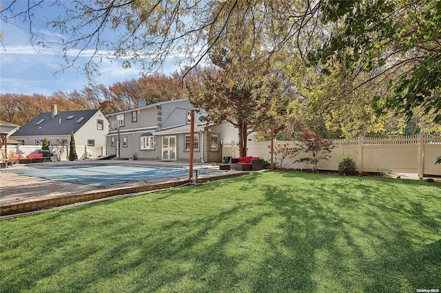 exterior space with a patio area, a yard, and a covered pool