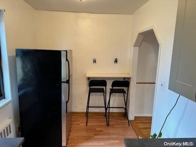 kitchen featuring black refrigerator and hardwood / wood-style flooring