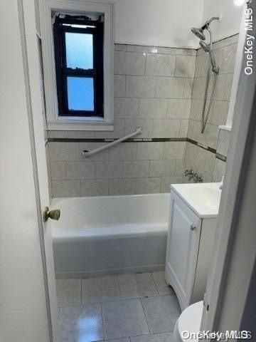 full bathroom with tile patterned flooring, vanity, toilet, and tiled shower / bath