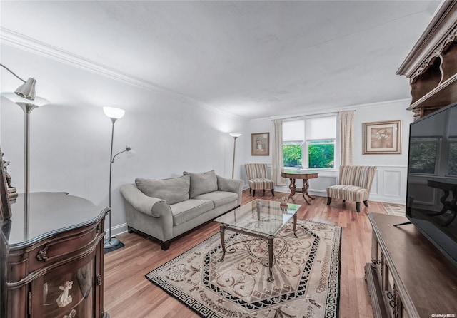 living room featuring light wood-type flooring and crown molding