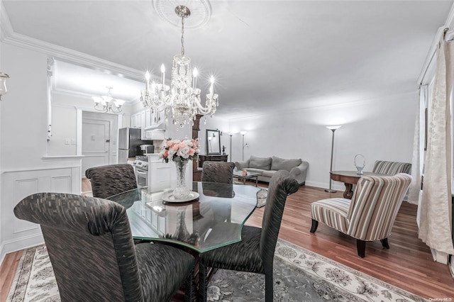 dining room with hardwood / wood-style flooring, crown molding, and a chandelier