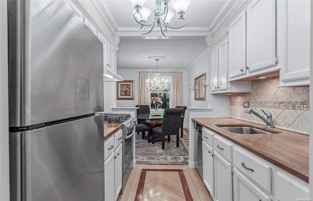 kitchen with butcher block countertops, a chandelier, decorative light fixtures, white cabinets, and appliances with stainless steel finishes