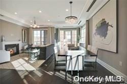 dining space with a raised ceiling and a chandelier