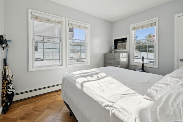 bedroom with parquet floors, baseboard heating, and a wall unit AC