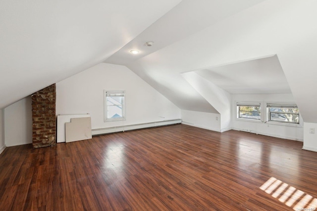 additional living space with vaulted ceiling, dark wood-type flooring, and a baseboard heating unit