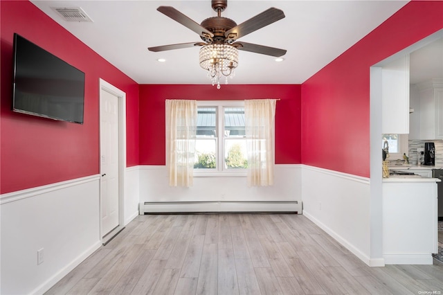 unfurnished dining area featuring ceiling fan, light hardwood / wood-style flooring, and a baseboard heating unit