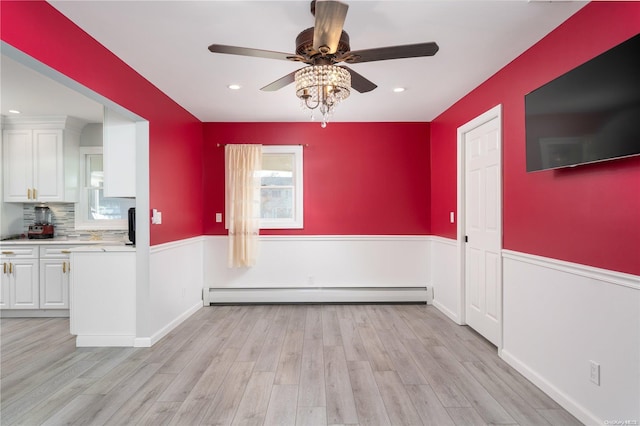 interior space with ceiling fan, light hardwood / wood-style flooring, and a baseboard heating unit