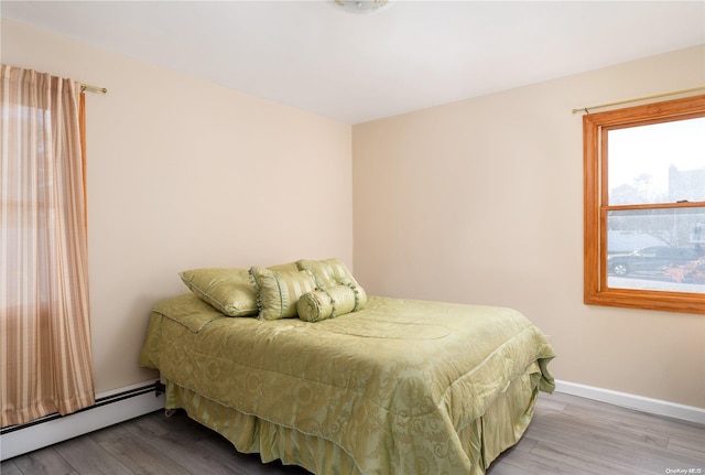 bedroom with wood-type flooring and baseboard heating