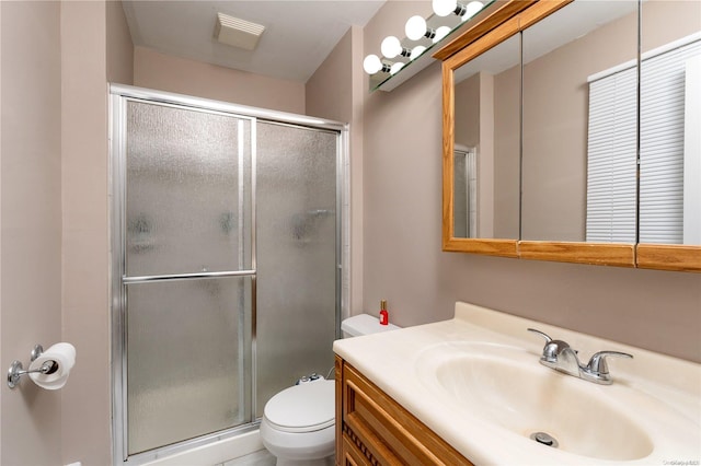 bathroom featuring vanity, toilet, and walk in shower