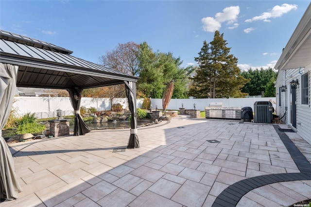 view of patio featuring a gazebo, central air condition unit, and an outdoor kitchen