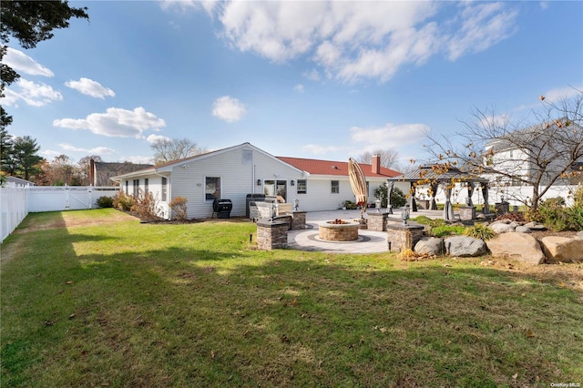 rear view of house with a gazebo, a patio area, a lawn, and a fire pit