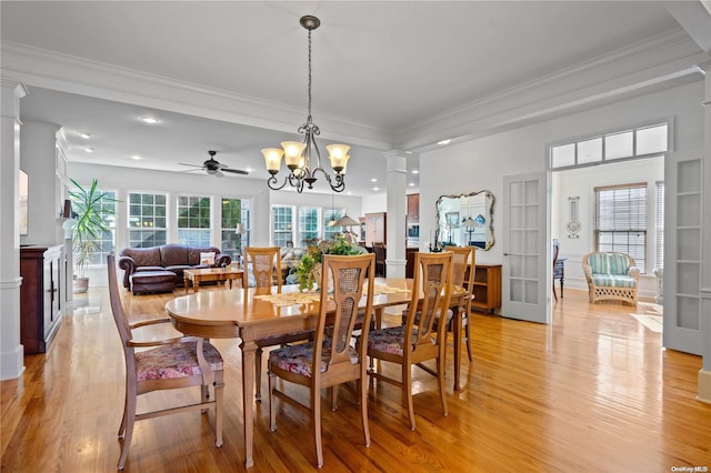 dining area with ornamental molding, ceiling fan with notable chandelier, and light wood-type flooring