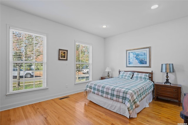 bedroom with multiple windows and wood-type flooring