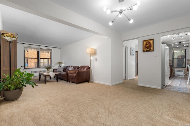 living room with radiator, light colored carpet, and a notable chandelier