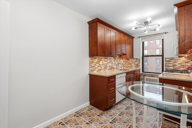 kitchen featuring white appliances, light stone counters, and backsplash