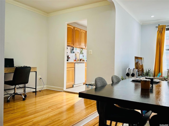 dining room with light wood-type flooring and crown molding