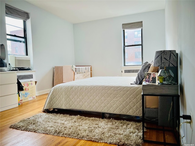 bedroom with hardwood / wood-style floors and multiple windows