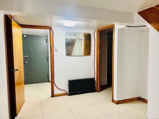 hall with radiator heating unit and light tile patterned floors