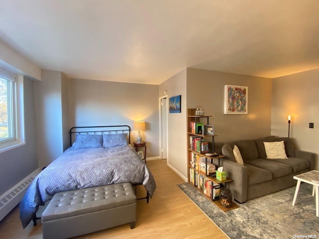 bedroom featuring light hardwood / wood-style floors and a baseboard radiator