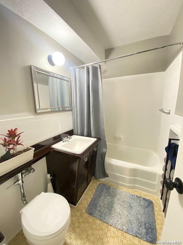 full bathroom with vanity, decorative backsplash, shower / bathtub combination with curtain, and toilet