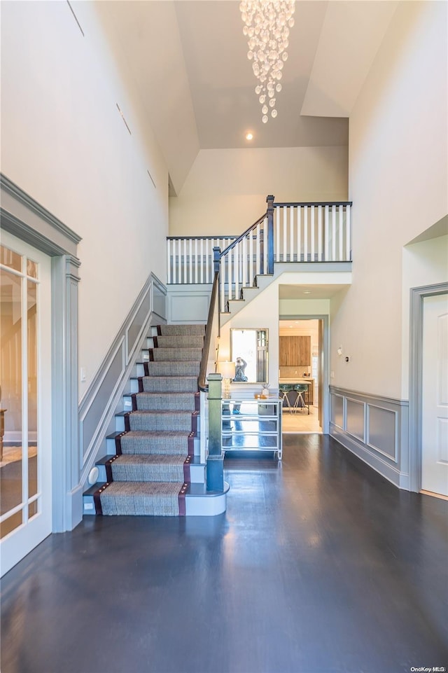 staircase featuring a high ceiling and a notable chandelier