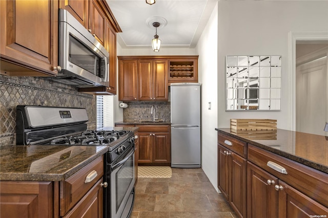 kitchen with backsplash, stainless steel appliances, dark stone countertops, and sink