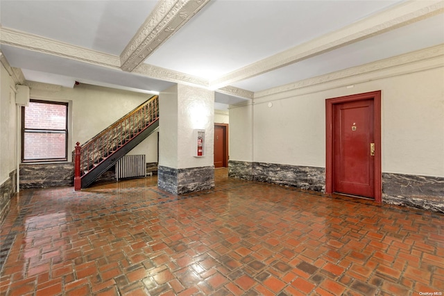 interior space with radiator heating unit and beamed ceiling