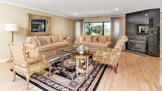 living room with crown molding and light wood-type flooring