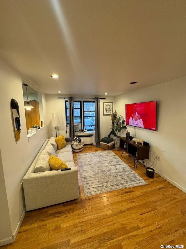 living room featuring recessed lighting, baseboards, and wood finished floors