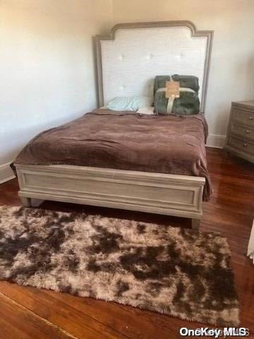 bedroom with dark hardwood / wood-style flooring