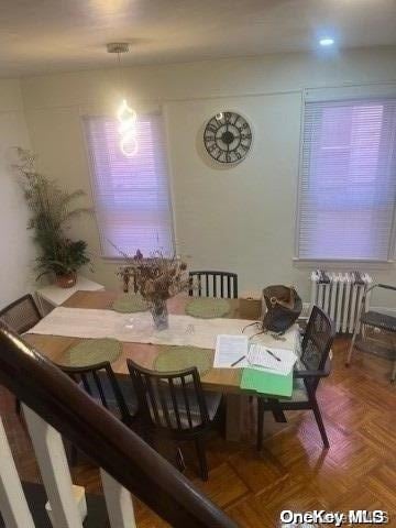 dining area featuring radiator and parquet floors