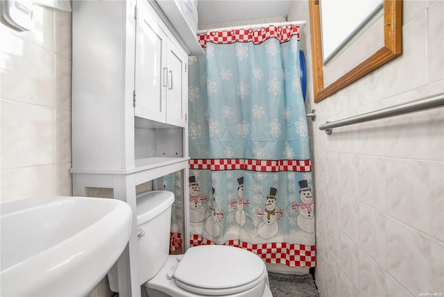 bathroom featuring toilet and tile walls