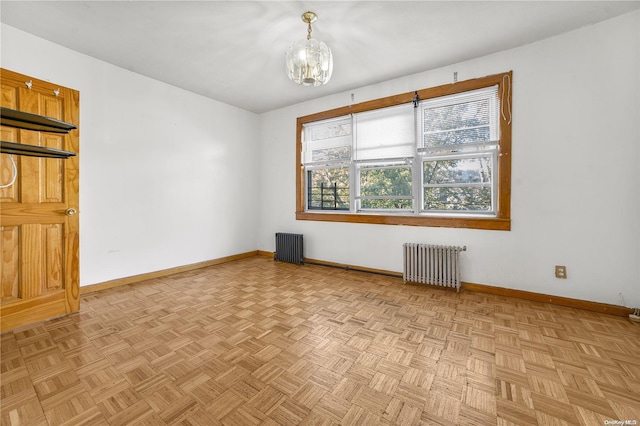 spare room with radiator heating unit and light parquet flooring