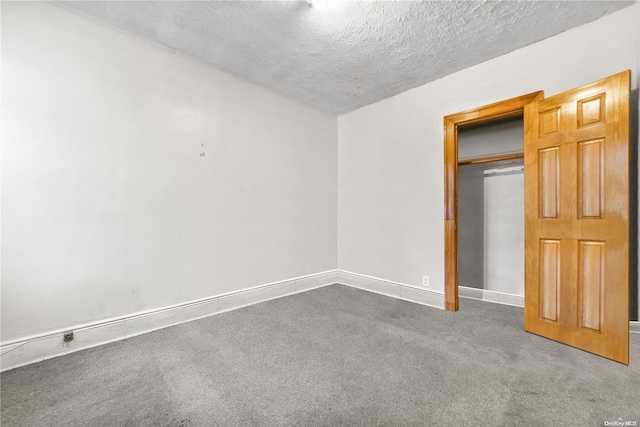 unfurnished bedroom with a textured ceiling, carpet floors, and a closet