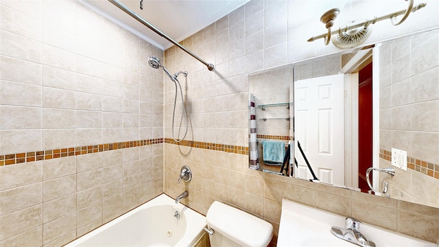 full bathroom featuring toilet, tiled shower / bath, tile walls, sink, and crown molding