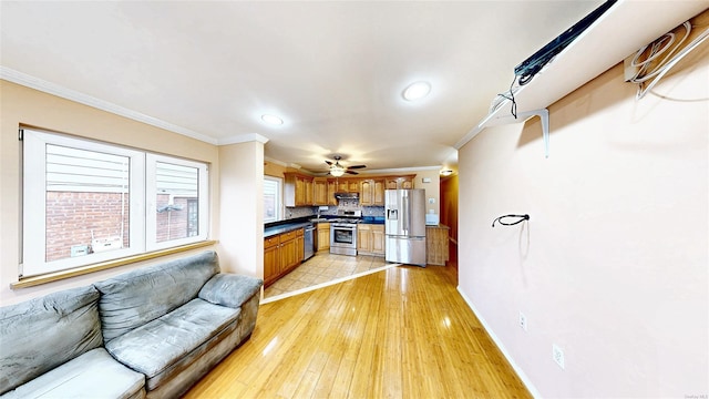 kitchen with exhaust hood, stainless steel appliances, backsplash, ornamental molding, and light hardwood / wood-style flooring