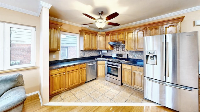 kitchen featuring stainless steel appliances, decorative backsplash, ornamental molding, ceiling fan, and light tile patterned floors