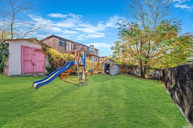 view of playground featuring a storage shed and a yard