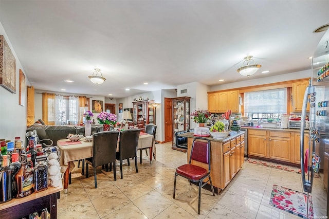 kitchen with sink, a kitchen island, and a healthy amount of sunlight