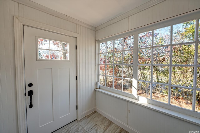 foyer with plenty of natural light and ornamental molding