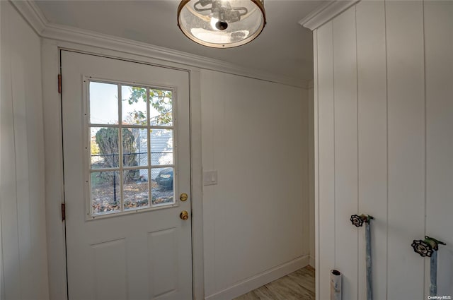 doorway to outside with crown molding and light wood-type flooring