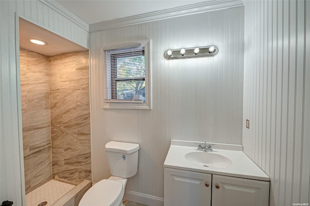 bathroom featuring crown molding, tiled shower, vanity, and toilet