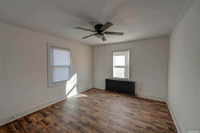 spare room with dark hardwood / wood-style flooring, crown molding, radiator heating unit, and ceiling fan