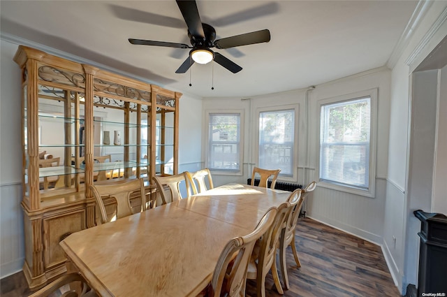 dining area featuring ceiling fan, ornamental molding, a healthy amount of sunlight, and dark hardwood / wood-style floors