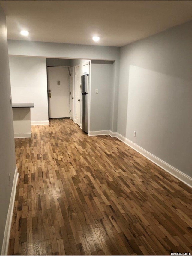 interior space with stainless steel fridge and dark hardwood / wood-style flooring