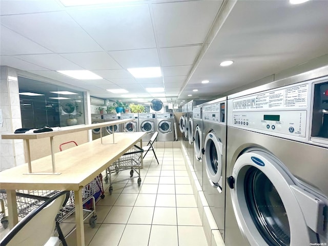 washroom with independent washer and dryer and light tile patterned floors