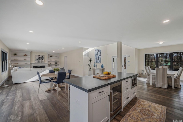 kitchen with white cabinets, a center island, dark hardwood / wood-style floors, and wine cooler