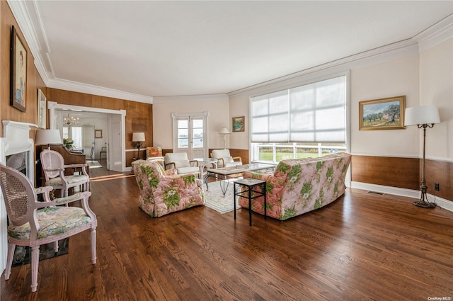 living room featuring dark hardwood / wood-style flooring, ornamental molding, and wood walls