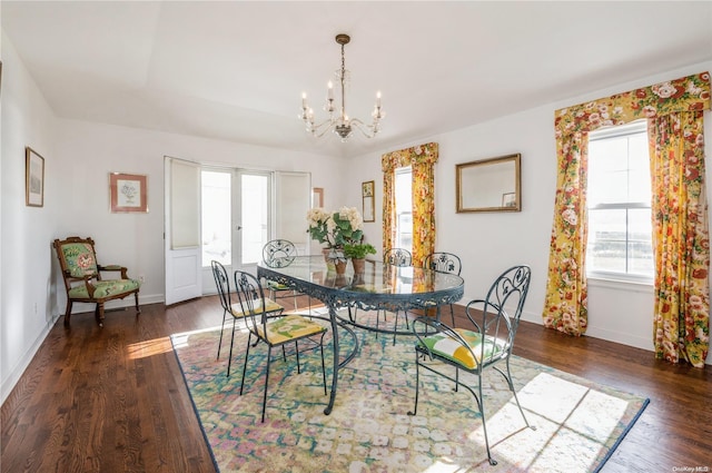 dining room with french doors, dark hardwood / wood-style floors, an inviting chandelier, and a healthy amount of sunlight